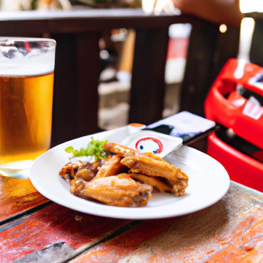 Asas de frango picantes com cerveja gelada em um quán nhậu xem bóng đá tphcm