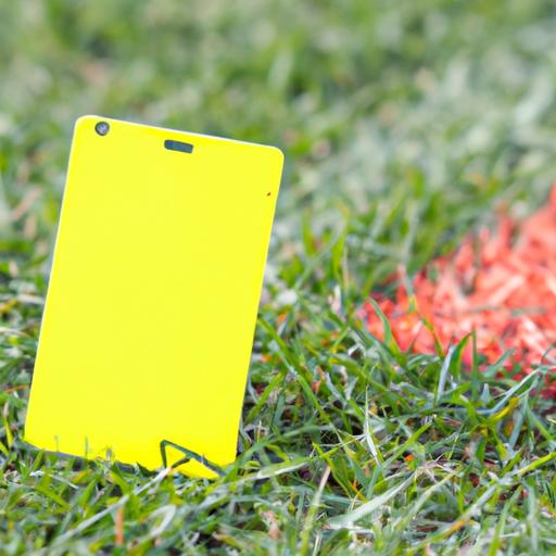 Close-up de um cartão amarelo caído no campo de futebol.